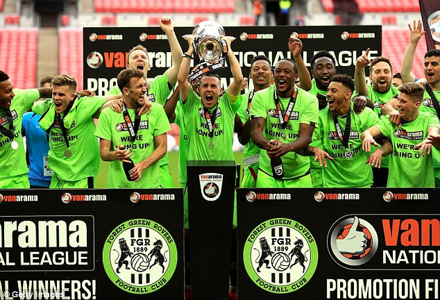 Forest Green Rovers players in green kit lifting the trophy after winning the National League promotion final