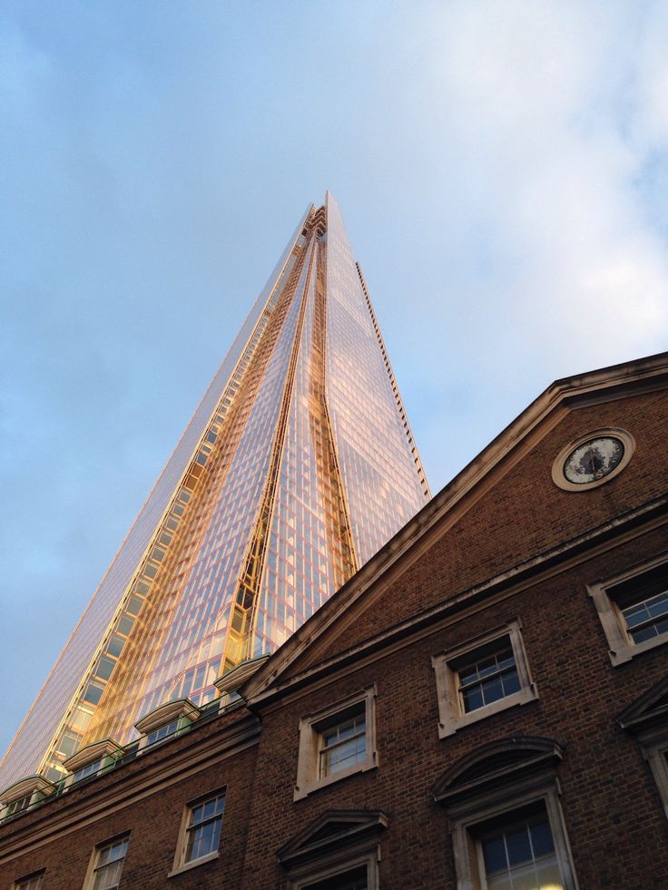 The Shard rising above a brick Georgian building, its glass lit gold by the evening sun