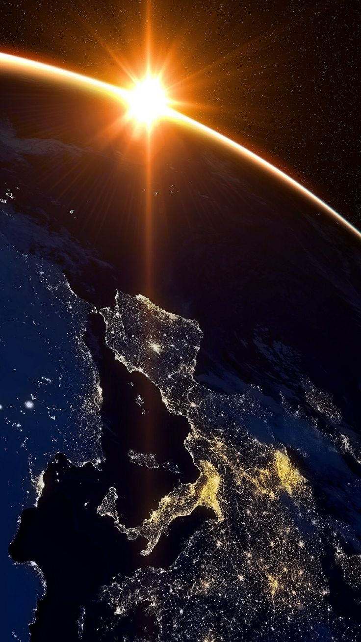 Europe seen from space at night, city lights glowing as the sun rises over the Earth's horizon