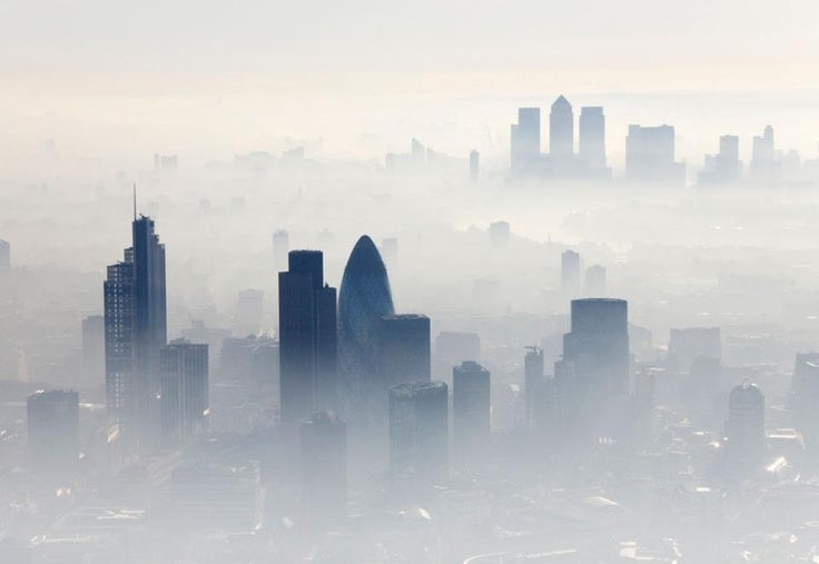 London skyline rising out of morning mist, with the Gherkin in front and Canary Wharf in the distance