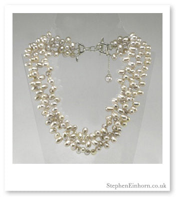 Multi-strand white freshwater pearl Contessa necklace with a silver clasp on a display stand