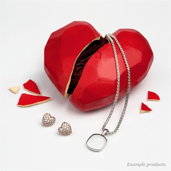 Pavé rose gold heart stud earrings and a silver pendant necklace beside a cracked red heart-shaped box