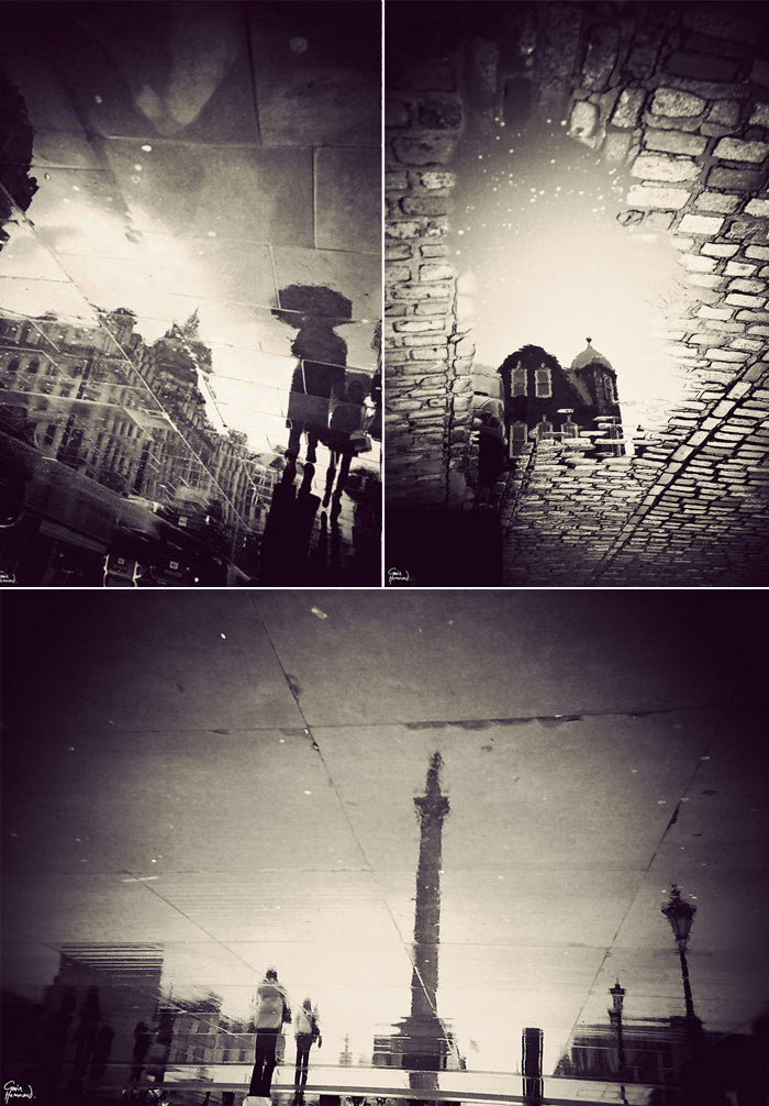 Black and white reflections of London in rain puddles, including an umbrella, a brick house and Nelson's Column