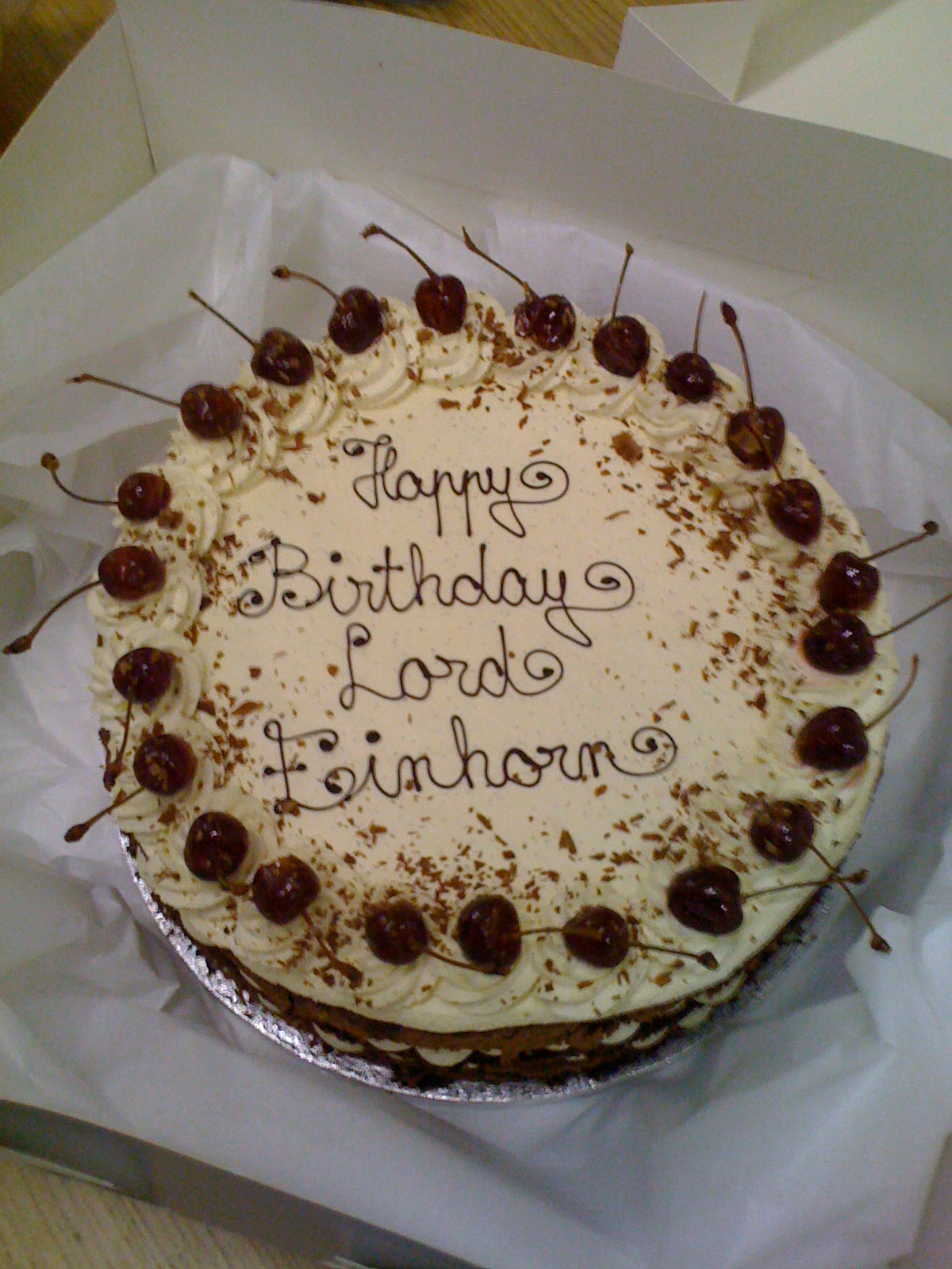 Black Forest cake topped with cherries and piped 'Happy Birthday Lord Einhorn' in chocolate