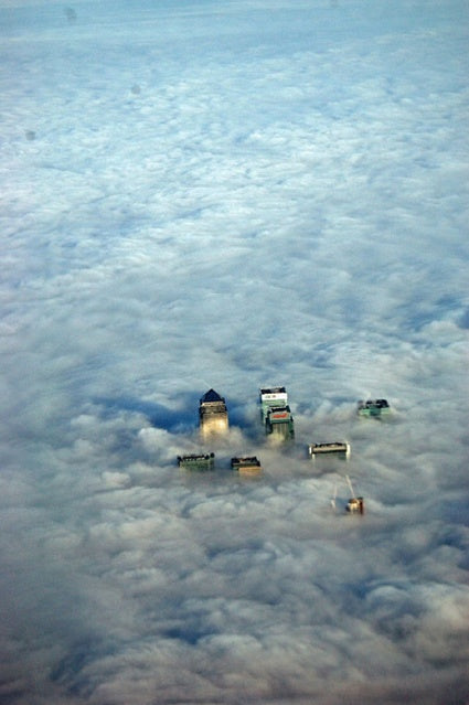 Canary Wharf towers poking through a blanket of low cloud, seen from above