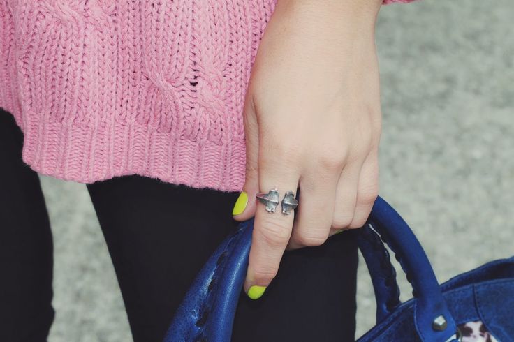 Silver hammerhead shark ring worn on a woman's finger, with yellow nail polish and a blue handbag