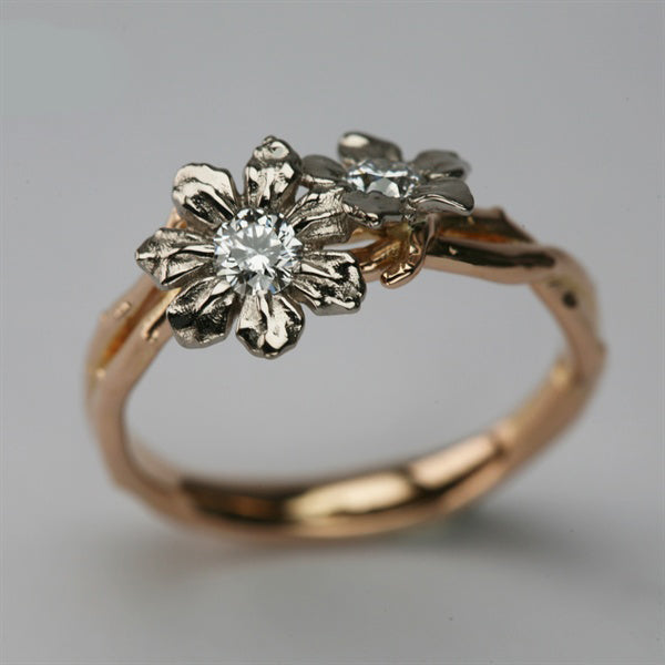 Rose gold twig-textured engagement ring with two white gold flowers, each set with a diamond
