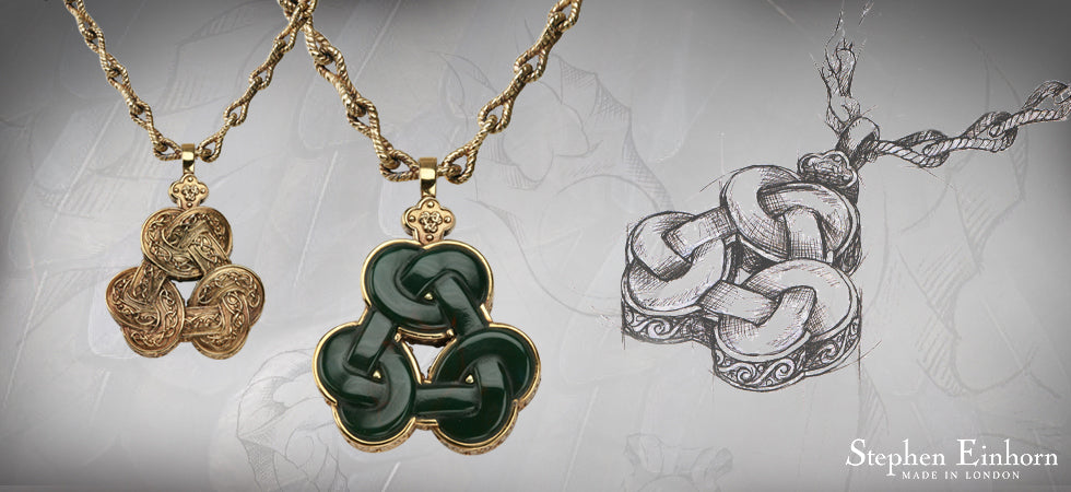 Gold knot pendant necklaces made for Maleficent, one set with dark green stone, beside the pencil design sketch