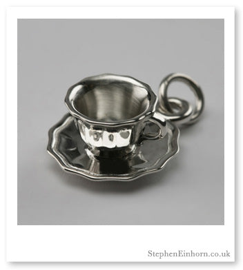 Sterling silver teacup and saucer charm on a jump ring, shown on a grey background