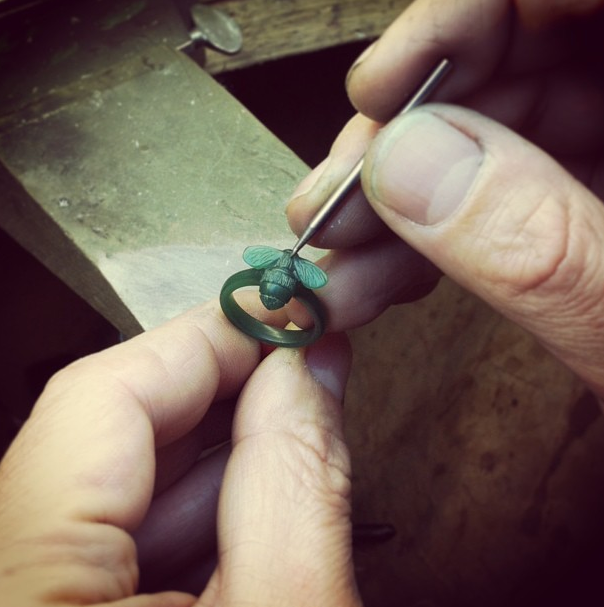 Jeweller carving the green wax model of the new Bumblebee ring at the workshop bench