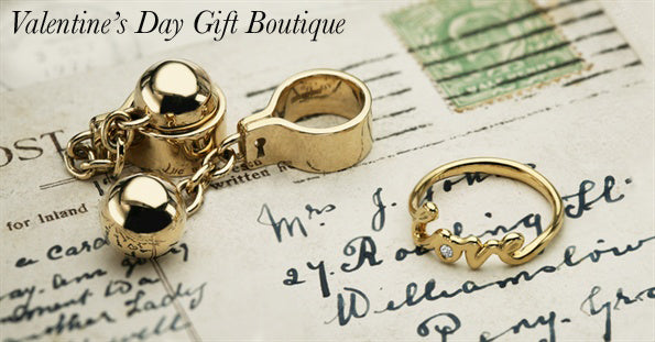 Gold ball and chain cufflinks and a gold love script ring with a diamond on a vintage handwritten postcard
