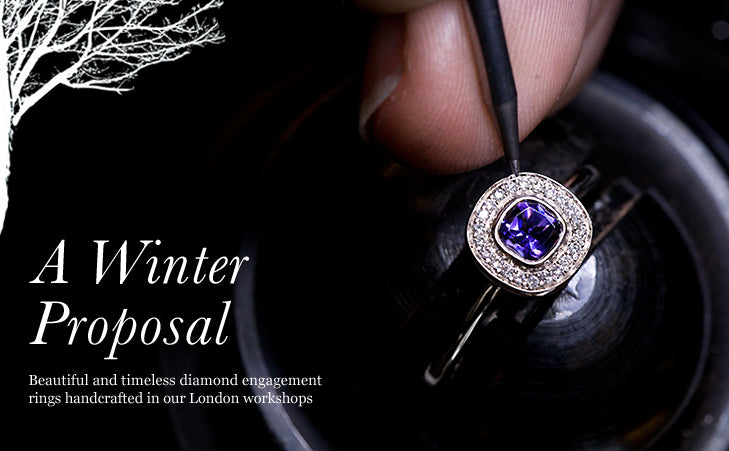 Jeweller holding a halo engagement ring with a violet centre stone and diamonds, text reads A Winter Proposal