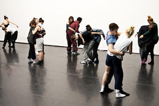 Dancers rehearsing in pairs on a black studio floor for Compass at Sadler's Wells
