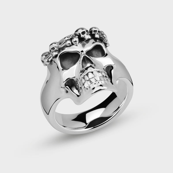 Silver crowned skull ring on a light gray background