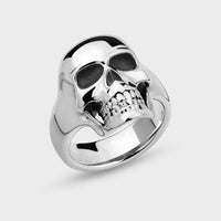 Silver full face skull ring on a light grey background