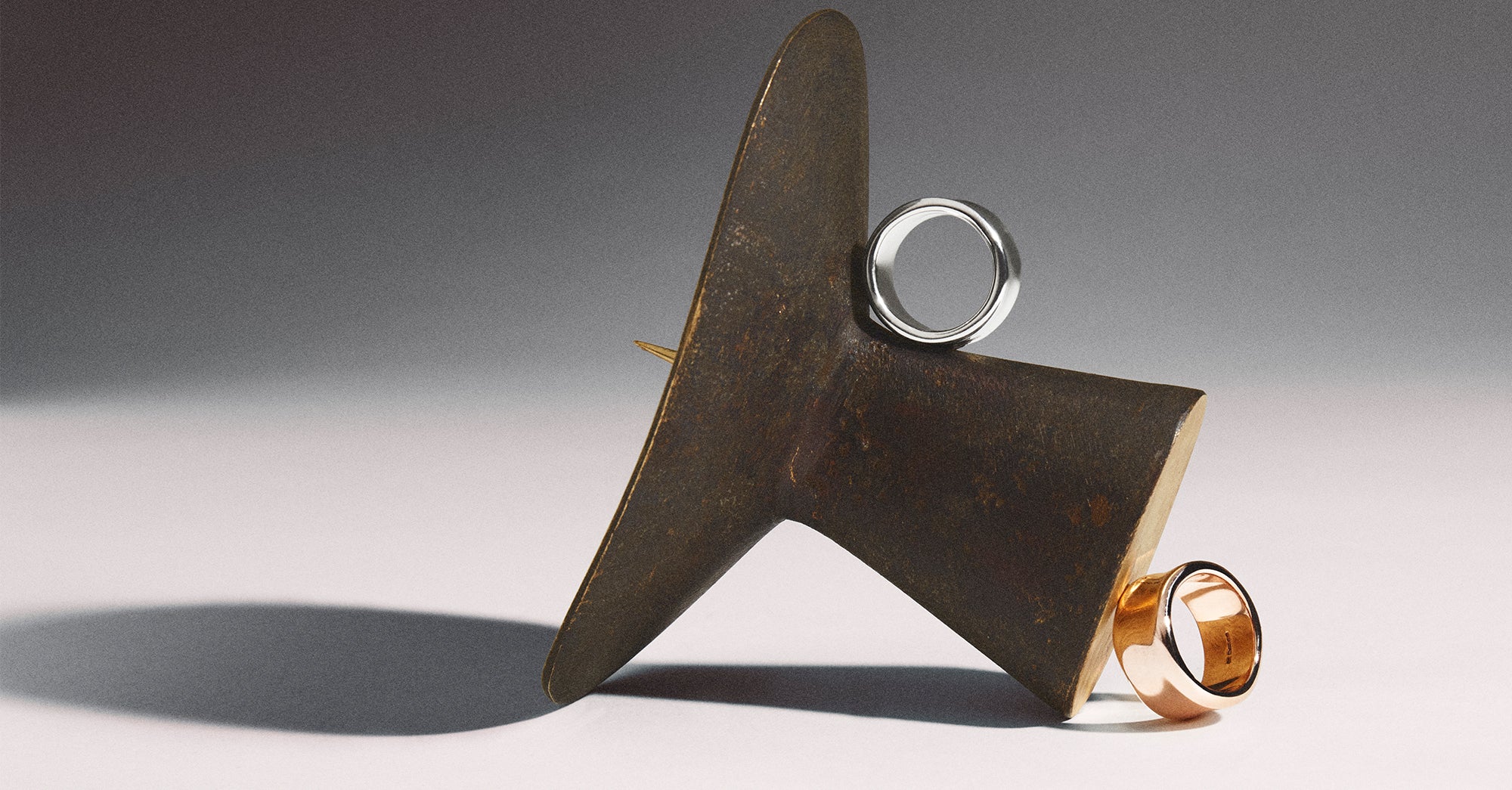 Smooth gold Liquid collection ring by Stephen Einhorn resting on a honey dipper, handcrafted luxury jewelry London