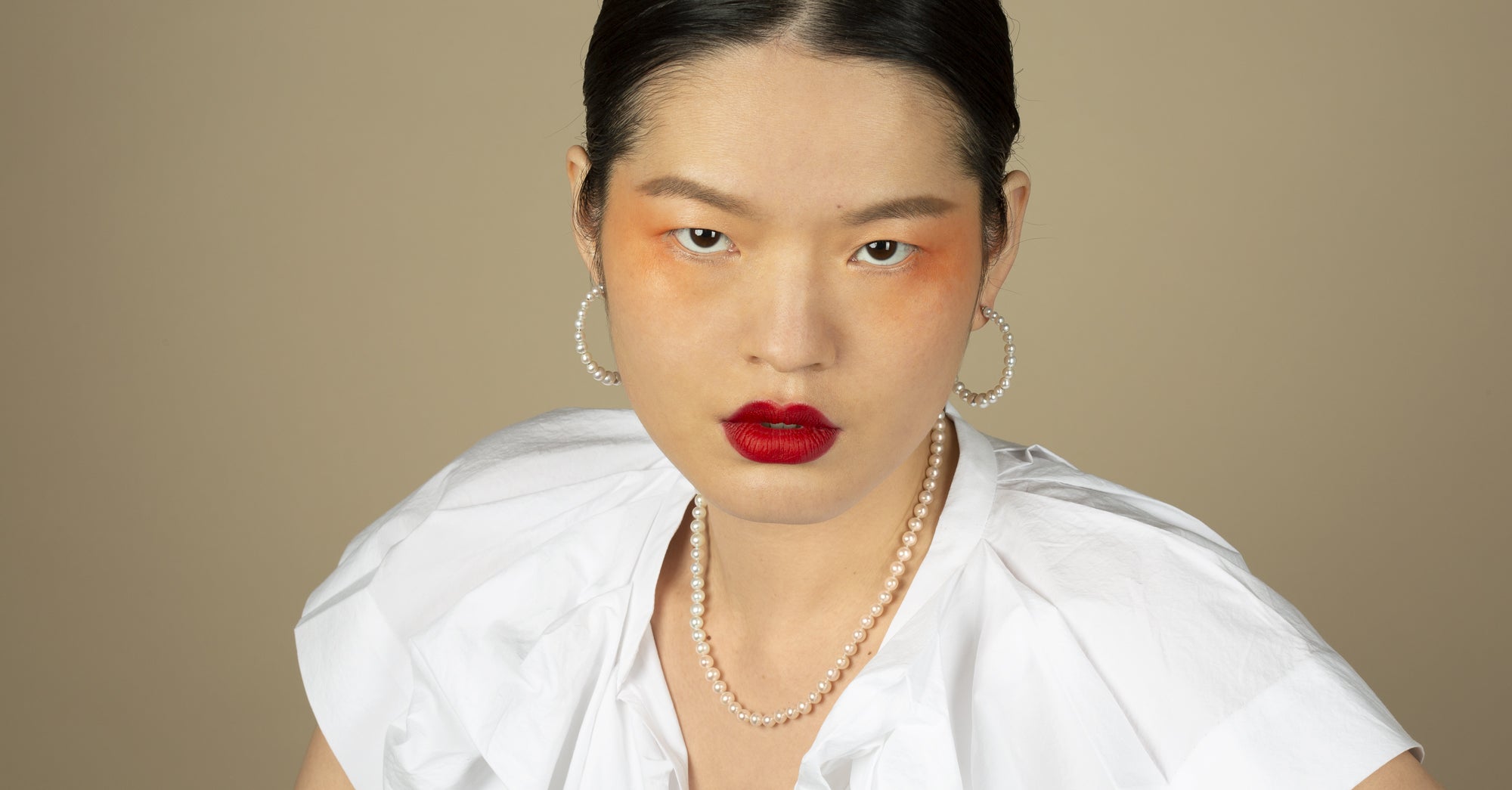 Model wearing layered pearl necklaces and drop earrings by Stephen Einhorn, luxury pearl jewelry handmade in London