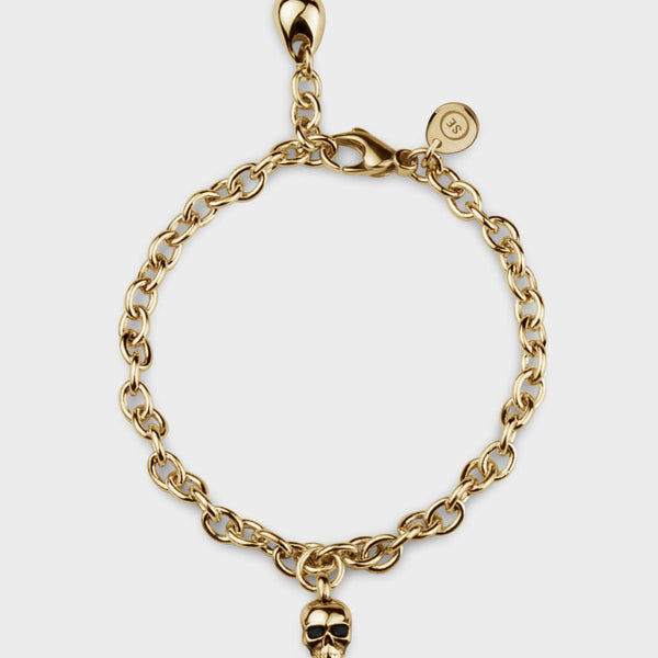A complete picture of a yellow gold skull charm bracelet. 