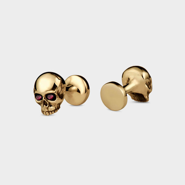 A close up of the back and front of a pair of yellow gold push through gold cufflinks. These have ruby eyes.