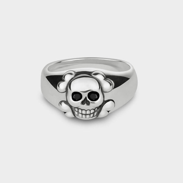 A close up of a smiling skull ring in silver